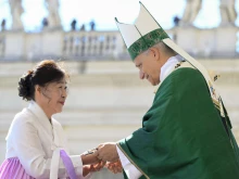 Pope Leo XIV hands a crucifix to a newly instituted catechist during Mass in St. Peter’s Square at the Vatican on Sept. 28, 2025.