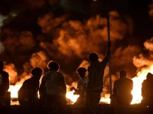 People look at burning tyres blocking a street in Bordeaux in south-western France on June 29, 2023, during riots and incidents nationwide after the killing of a 17-year-old boy by a police officer's gunshot following a refusal to comply in a western suburb of Paris.