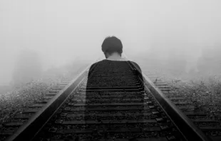 Ghostly man on train tracks / Photo by Gabriel on Unsplash 