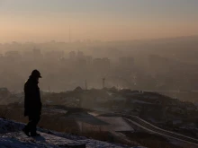 This picture taken on Jan. 16, 2022, shows a man watching smoke hanging over houses on a polluted day in Ulaanbaatar, the capital of Mongolia.