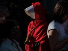 Pamela Smith dressed as characters of "The Handmaids Tale" walks with a noose around her neck as she joins pro-choice protesters gather in large numbers in front of the federal building to defend abortion rights in San Francisco on May 3, 2022.