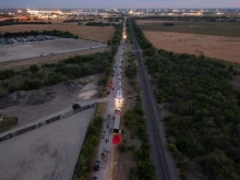 In this aerial view, members of law enforcement investigate a tractor trailer on June 27, 2022 in San Antonio, Texas. According to reports, at least 46 people, who are believed migrant workers from Mexico, were found dead in an abandoned tractor trailer. Over a dozen victims were found alive, suffering from heat stroke and taken to local hospitals.