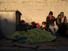 Migrants wake up after spending the night outside the immigration detention center where at least 38 migrants died during a fire in Ciudad Juarez, Chihuahua state, Mexico, on March 29, 2023.