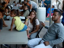 Dainelys Soto, Genesis Contreras, and Daniel Soto, who arrived from Venezuela after crossing the U.S. border from Mexico, wait for dinner at a hotel provided by the Annunciation House on Sept. 22, 2022, in El Paso, Texas.