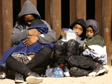 Immigrants seeking asylum in the United States wait as they are processed by U.S. Border Patrol agents in the early morning hours after crossing into Arizona from Mexico on May 10, 2023 in Yuma, Arizona.