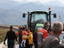 Refugees wait next to a line of vehicles near the border town of Kornidzor, Armenia, arriving from Nagorno-Karabakh, on Sept. 26, 2023.