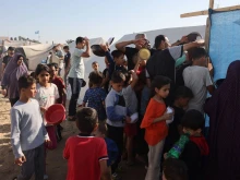 Displaced Palestinians who fled their houses amid Israeli strikes wait at a food distribution point as they shelter in tents set up in a United Nations-run center following Israel's call for more than 1 million civilians in northern Gaza to move south, in Khan Yunis, in the southern Gaza Strip on Oct. 26, 2023, amid the ongoing battles between Israel and the Palestinian group Hamas.