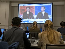 Florida governor and Republican presidential hopeful Ron DeSantis (left) and California Gov. Gavin Newsom appear on screen from the press room during a debate held by Fox News in Alpharetta, Georgia, on Nov. 30, 2023.