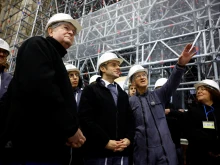 French President Emmanuel Macron, flanked by president of the public establishment "Rebuilding Notre-Dame de Paris" Philippe Jost (right) and and Archbishop of Paris Laurent Ulrich (left), visits the nave of the Notre-Dame de Paris Cathedral during its reconstruction on Dec. 8, 2023.
