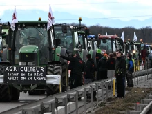 French farmers stand next to their tractors as they block the road during a demonstration at the French-German border in Ottmarsheim, eastern France, on Feb. 1, 2024, as part of nationwide protests called by several farmers’ unions over pay, tax, and regulations.
