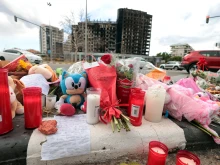 Flowers and candles are laid out on the sidewalk on Feb. 26, 2024, after a huge fire killed 10 people in a multi-story residential block in Valencia, Spain, on Feb. 22.
