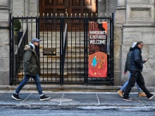 People walk past a church displaying a “Immigrants & Refugees Welcome” sign in New York on Jan. 24, 2025.