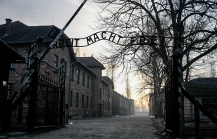 The sun rises over the main gate with the renowned sign “Arbeit Macht Frei” (“Work makes you free”) of the Museum of Auschwitz/Birkenau German Nazi concentration and extermination camp on the 80th anniversary of the liberation of the camp, Monday, Jan. 27, 2025. Credit: Dominika Zarzycka/SOPA Images/LightRocket/Getty Images