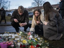 People light candles at a makeshift vigil near the adult education center Campus Risbergska school in Örebro, Sweden, on Feb. 5, 2025, one day after a shooting there left 11 people dead.
