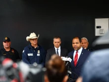 Dallas Mayor Eric Johnson (right) speaks during a press conference following a shooting at a U.S. Immigration and Customs Enforcement (ICE) detention facility in Dallas on Sept. 24, 2025. A detainee was killed and two were wounded in a sniper attack Wednesday on an ICE facility in Dallas, officials said.
