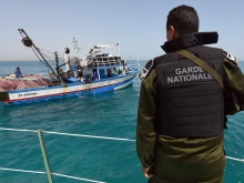 A member of the Tunisia’s national guard stops a fishing boat in the sea bordering Tunisia and Libya as they check vessels for illegal migrants trying to reach Europe, Tuesday, May 5, 2015.