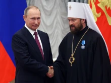 Russian President Vladimir Putin shakes hands with Russian Orthodox Church Bishop Hilarion Alfeyev during a state  ceremony at the Kremlin in Moscow on Sept. 22, 2016.