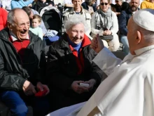 Pope Francis greets an elderly couple at a general audience in St. Peter's Square at the Vatican.