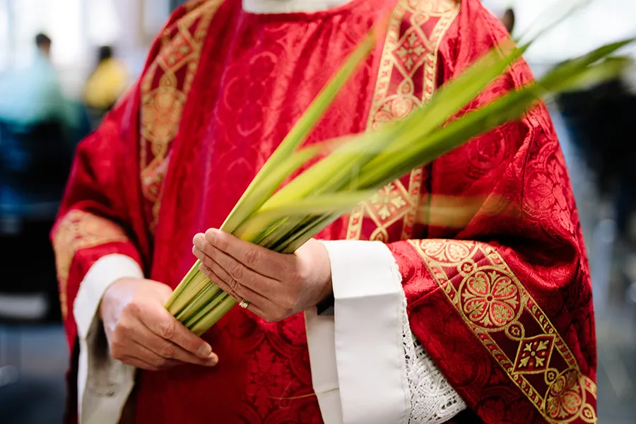 A priest holds palms on Palm Sunday.?w=200&h=150