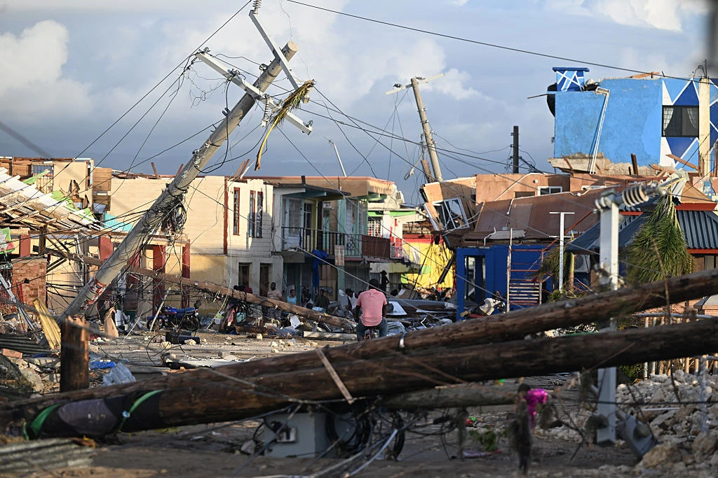Electrical poles are down as a man bikes through the destroyed neighborhood of North Street following the passage of Hurricane Melissa in Black River, Jamaica, on Oct. 29, 2025.?w=200&h=150