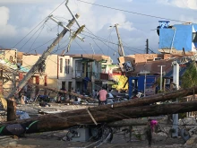 Electrical poles are down as a man bikes through the destroyed neighborhood of North Street following the passage of Hurricane Melissa in Black River, Jamaica, on Oct. 29, 2025.