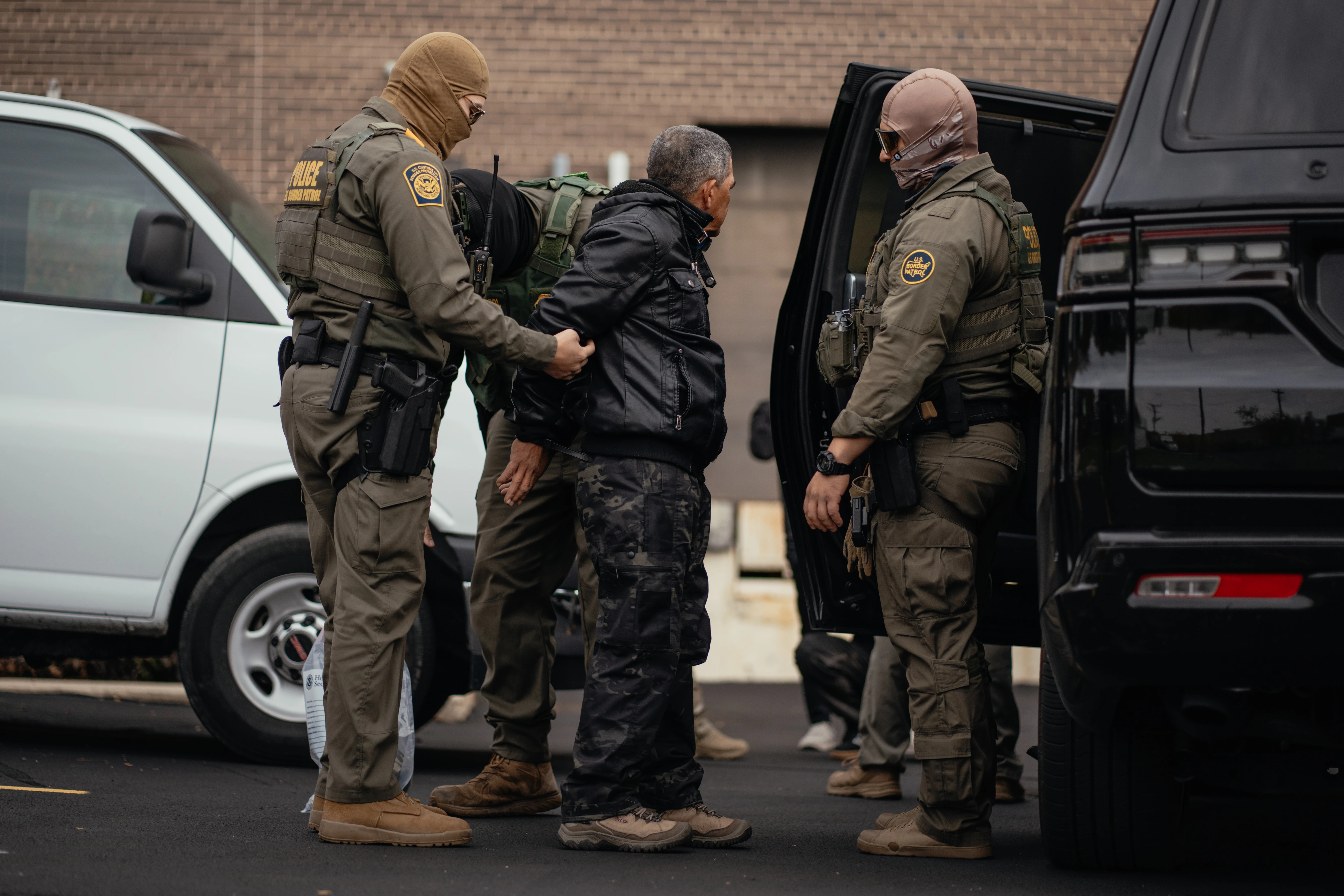 A person detained is taken to a parking lot on the far north side of the city before being transferred to an Immigration and Customs Enforcement facility in Chicago on Oct. 31, 2025.?w=200&h=150
