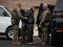 A person detained is taken to a parking lot on the far north side of the city before being transferred to an Immigration and Customs Enforcement facility in Chicago on Oct. 31, 2025.