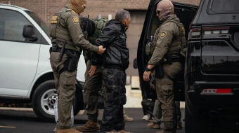 A person detained is taken to a parking lot on the far north side of the city before being transferred to an Immigration and Customs Enforcement facility in Chicago on Oct. 31, 2025.