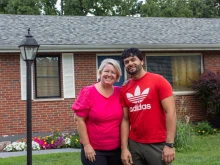 Ann Wittman with Farid Wardak, an Afghan immigrant, in front of the house that the Wittmans purchased for the Wardak family in the St. Louis suburb of Affton.