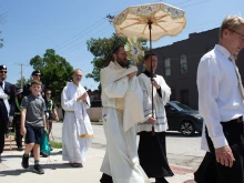 Father Aaron Nord, pastor of St. Stephen Protomartyr Church, carries the Eucharist through St. Louis on the way to his parish.