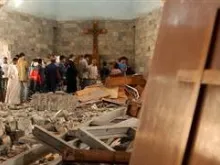 Iraqis survey damage to a church attacked by terrorists