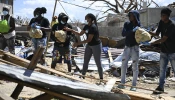 Residents help move food supplies at a community center before distribution to the Whitehouse community in Westmoreland, Jamaica, one of the areas most severely affected by the passage of Hurricane Melissa, on Nov. 2, 2025.