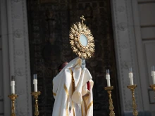 Bishop Andrew Cozzens holds the Eucharist over the faithful for benediction while standing on the Indiana War Memorial.