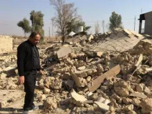 A priest examines a church destroyed by Islamic State militants in Karemlesh. Photo courtesy of the Knights of Columbus.