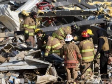 Emergency workers search through what is left of the Mayfield Consumer Products Candle Factory after it was destroyed by a tornado in Mayfield, Kentucky, on December 11, 2021.