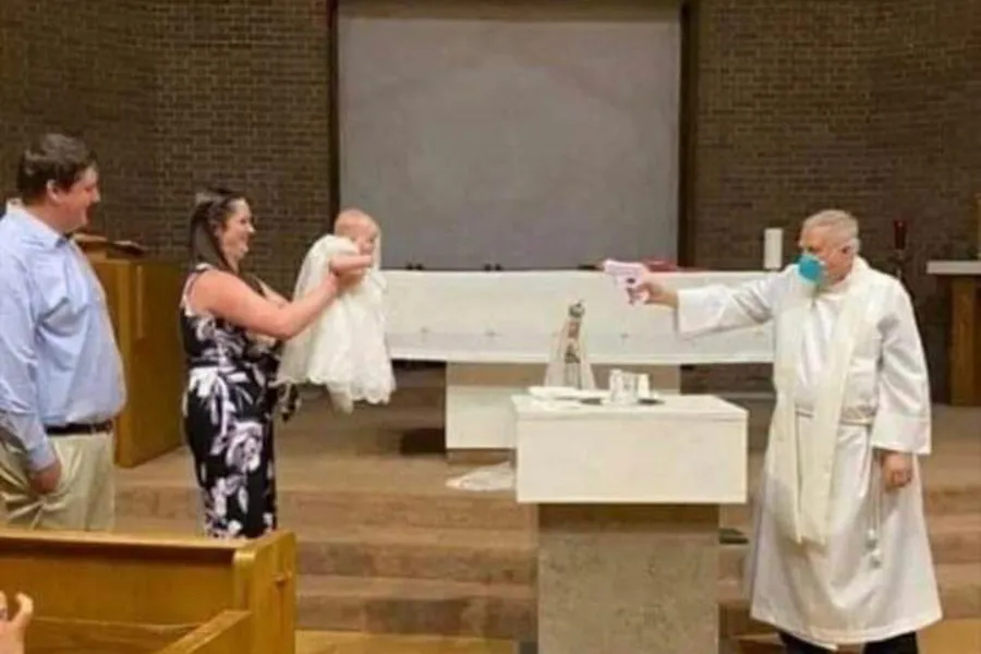 Fr. Stephen Klasek pretends to shoot water at a baby in this now-viral photo. ?w=200&h=150