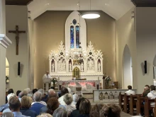 The faithful pray before the altar at Knock Shrine in Knock, Ireland, Friday, Aug. 15, 2025.