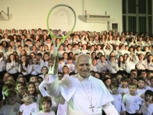 Pope Leo XIV holds up a tennis racket given to him by children of the Pope Paul VI Pontifical School in Castel Gandolfo on Dec. 16, 2025.