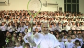 Pope Leo XIV holds up a tennis racket given to him by children of the Pope Paul VI Pontifical School in Castel Gandolfo on Dec. 16, 2025.