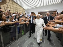 Pilgrims reach out to Pope Leo XIV at the general audience in the Paul VI Audience Hall, Vatican City, Wednesday, Aug. 27, 2025.