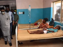 State officials walk past injured victims on hospital beds being treated for wounds following an attack by gunmen at St. Francis Xavier Catholic Church in Owo, southwest Nigeria, on June 5, 2022.