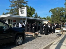 Dozens of Religious Sisters of Mercy of Alma, Michigan, stop at Merrill Whippy Dip in rural Michigan to celebrate a postulant member’s profession of vows for religious life with Bishop Robert D. Gruss of Saginaw, near Lake Huron, on Aug. 16, 2023.