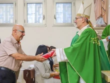 Patriarch Cardinal Pierbattista Pizzaballa presents a Bible to a catechism teacher on Sept. 27, 2025, in Galilee.