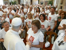 Members of St. Francis’ Work for the Poor, wearing T-shirts with the phrase “a helping hand to man every day,” meet with Pope Leo XIV on Sept. 1, 2025, in the Vatican’s Clementine Hall.