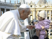 Pope Leo XIV greets a baby during the general audience in November 2025.