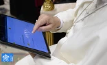 Pope Leo XIV uses a tablet to navigate the website of the new digital version of the Vatican's Pontifical Yearbook, known as the "Annuario Pontificio" in Italian.