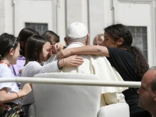 Youngsters surrounding Pope Francis in the popemobile.