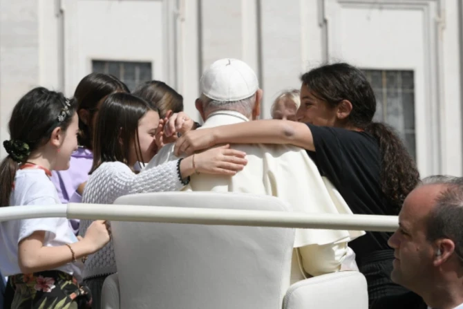 Pope Francis in popemobile surrounded by kids