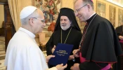 Archbishop Gintaras Grušas and Greek Orthodox Archbishop Nikitas Loulias present the signed updated Ecumenical Charter to Pope Leo XIV on Nov. 6, 2025.