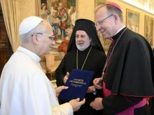 Archbishop Gintaras Grušas and Greek Orthodox Archbishop Nikitas Loulias present the signed updated Ecumenical Charter to Pope Leo XIV on Nov. 6, 2025.